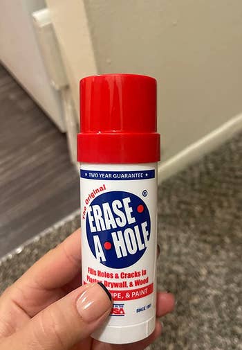 Reviewer holding their Erase-A-Hole putty