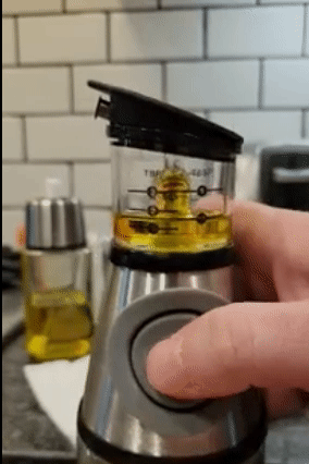 gif of reviewer pressing a button on the oil dispenser to measure the oil