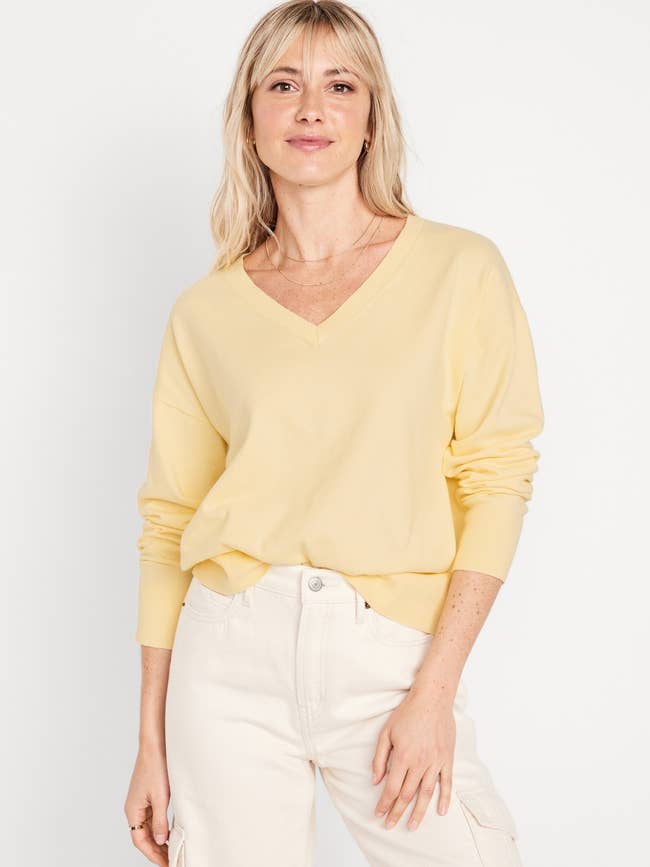 a model wearing a light yellow v-neck sweater