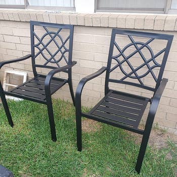 Reviewer image of black wrought iron chairs with arm rests against a brick wall