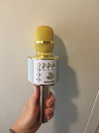a reviewer photo of someone holding the microphone in yellow