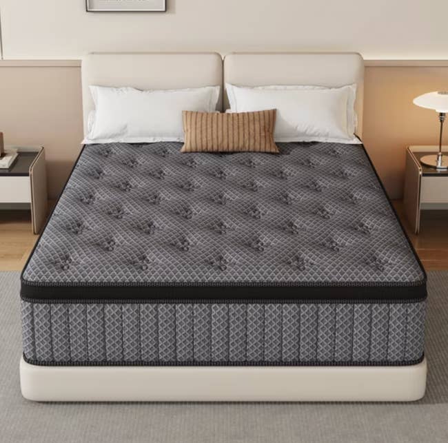 A neatly arranged chamber with a plush, patterned mattress connected a treble bed, flanked by nightstands and a lamp, creating a cozy setting