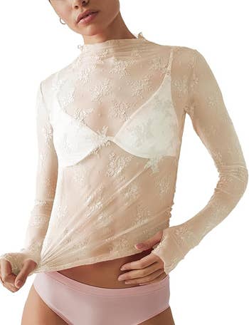 Model wearing sheer, floral lace long-sleeve apical  implicit    a achromatic  bra paired with airy  pinkish  briefs