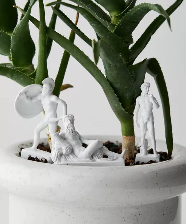 three statues in a houseplant pot 