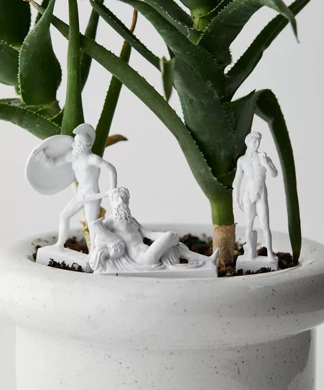 three statues in a houseplant pot 