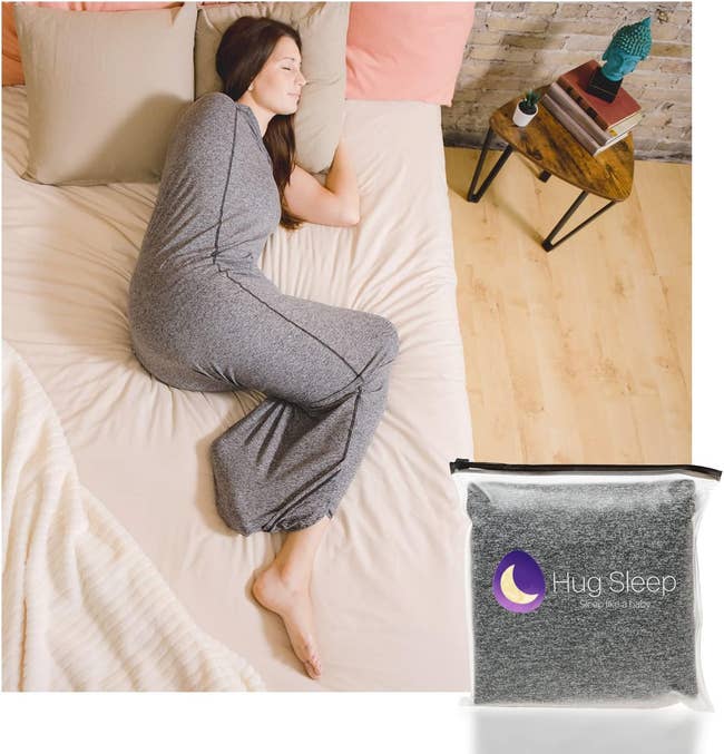 Model sleeping in a gray cocoon-like compression blanket with their feet and head poking out 