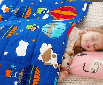different toddler with hot air balloon blanket at nap time