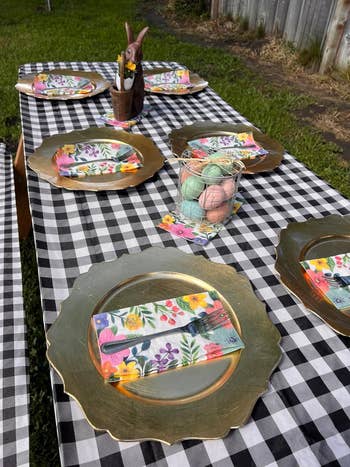 Outdoor table setting with patterned plates, napkins, and a centerpiece on a checkered tablecloth for a shopping article