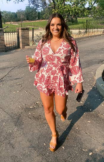 a reviewer wearing the red and white floral romper