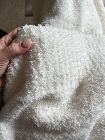 a reviewer with a white plush blanket