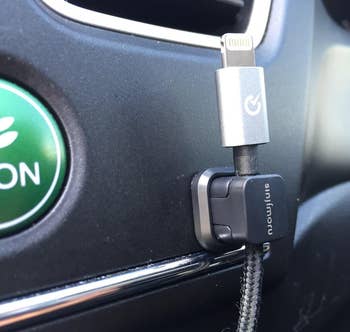 another reviewer image showing close up of the black clip holding a charging cable in the car 