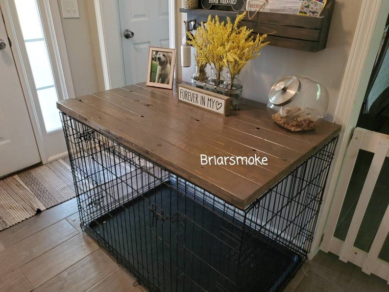 a dog kennel with a wood panel on top