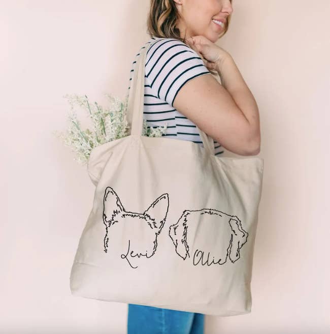 model with white tote with black outline of two dogs ears and names