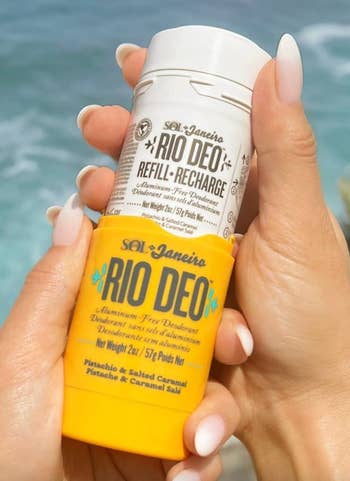 Hand holding Sol de Janeiro Rio Deo antiperspirant stick above water. Text calls out refillable packaging