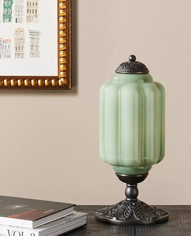 Vintage-style green glass jar on a table with books
