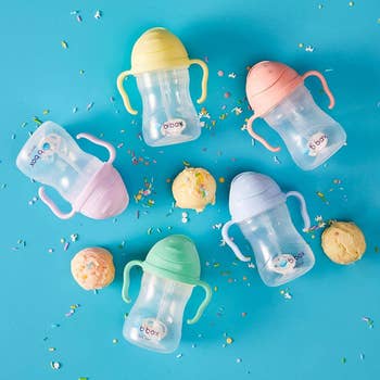 five sippy cups with fun colored pastel lids