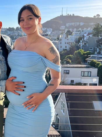 Person successful  a bluish  formal  holding their babe  bump