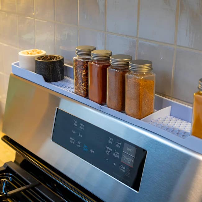 Stoples bumbu yang tertata rapi di rak rak kompor, menawarkan solusi penyimpanan dapur yang terorganisir