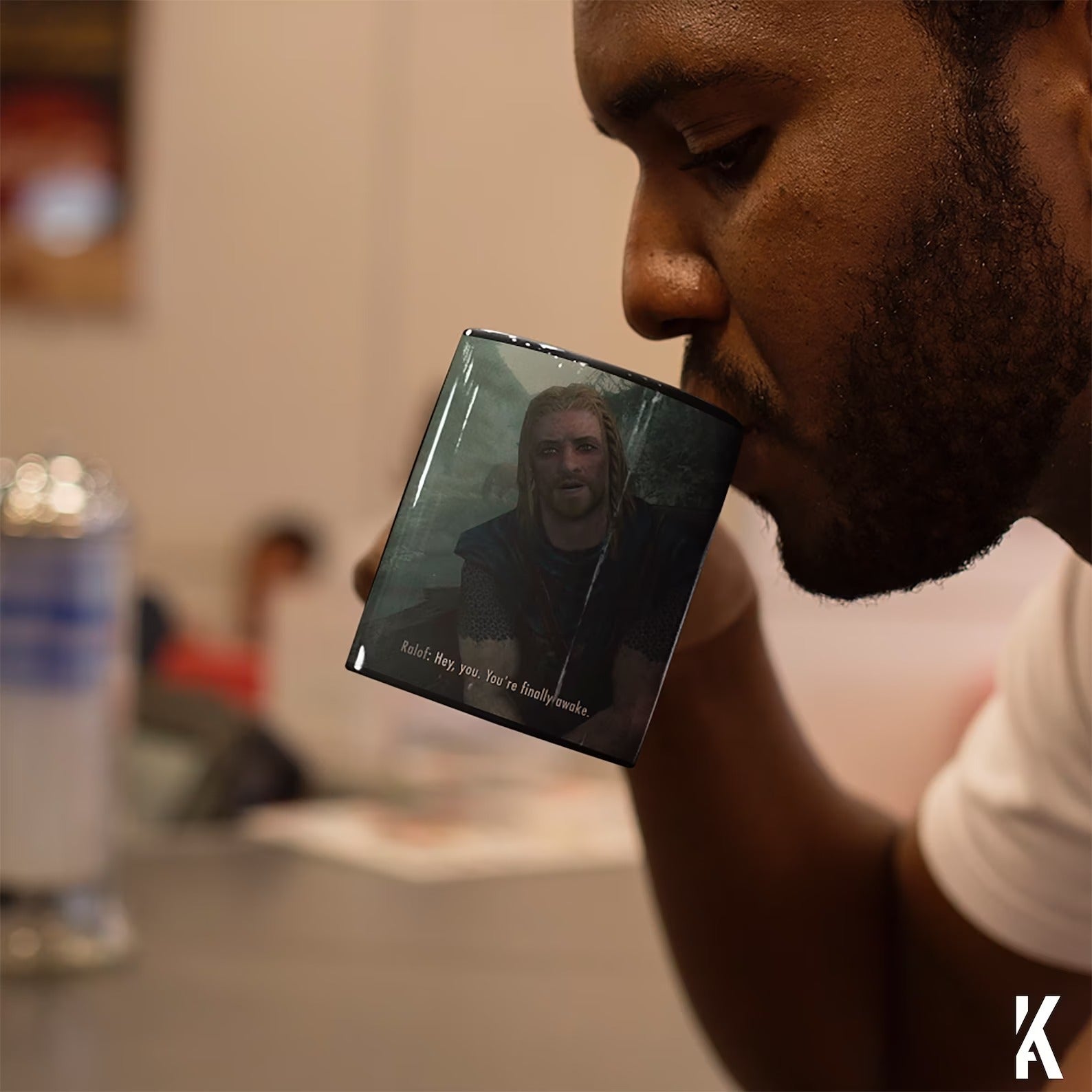 A guy drinking from Skyrim mug