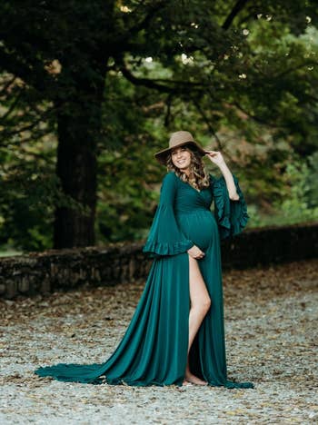 model posing in green maxi gown with long train