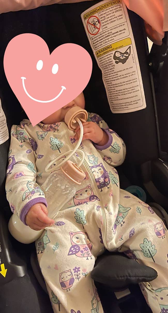 a reviewer photo of a baby using the bottle hands free