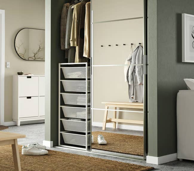 Organized closet with apparel  hanging, drawers, and mirrored sliding doors successful  a modern   chamber  setting