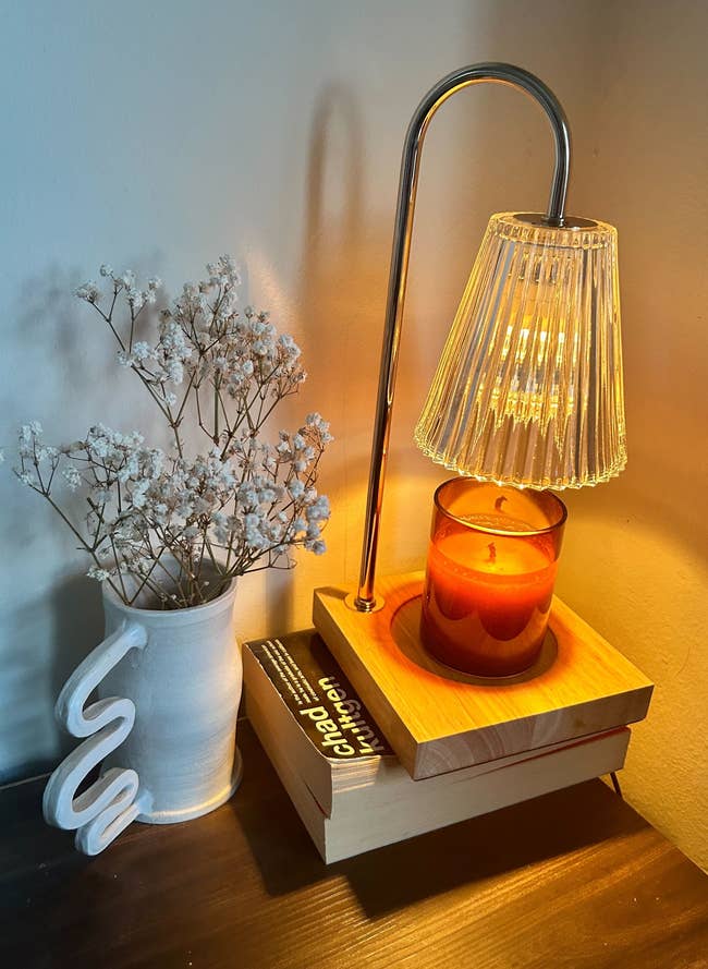the candle warmer turned on with a candle underneath the bulb