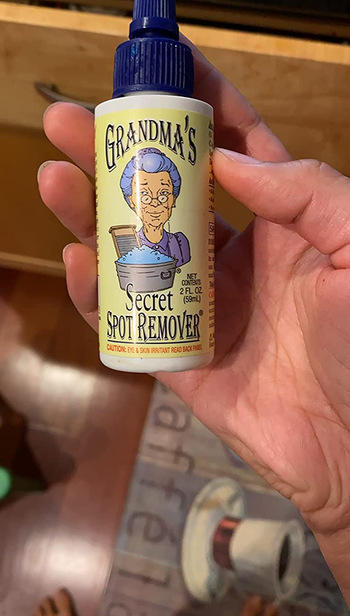 reviewer photo of them holding a bottle of stain remover