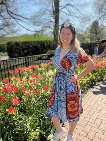 Woman in a patterned dress standing in a garden for a shopping article