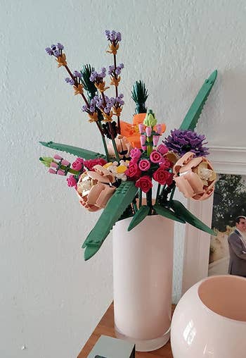 the same bouquet of lego flowers in a tall white vase
