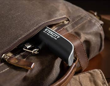 A portable Etekcity digital luggage scale being placed into a brown bag’s pocket, highlighting its compact design for easy storage and portability. Text: