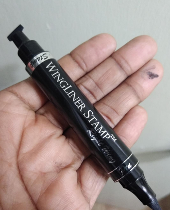 a reviewer hand holding the eyeliner pen/stamp 