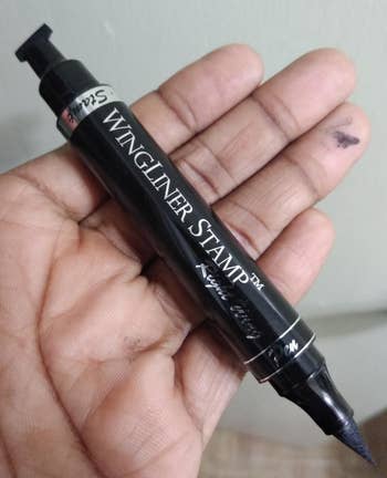 a reviewer hand holding the eyeliner pen/stamp 