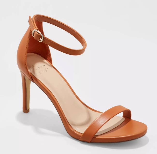 a brown shoe with a high thin heel and an ankle strap