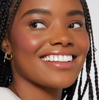 Model wearing pink blush on their cheeks 