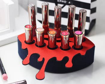 Black mouth-shaped lipstick organizer with red dripping lipstick