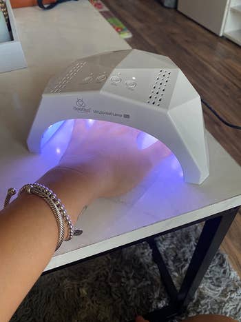 reviewer photo of them using a gel nail lamp