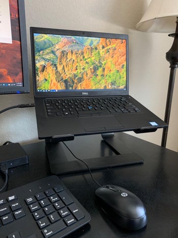 a reviewer's black laptop on the black stand