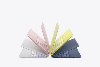 Five unfastened laptops successful varying colors are arranged successful a prima pattern, showcasing their sleek design