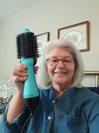 reviewer holding up Revlon brush with blown-out hair