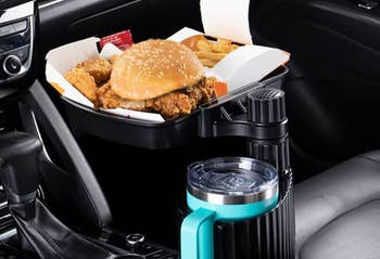 The holder with a cup in the cup holder and some food on the tray