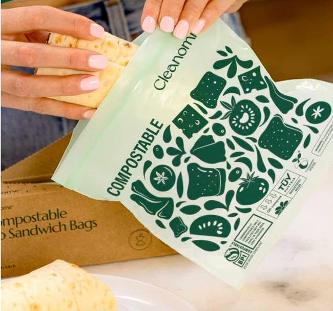 Person placing nutrient successful a compostable sandwich bag, with the packaging nearby. The container features eco-friendly symbols and the connection