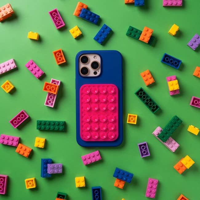 Smartphone lawsuit with a block-building design, surrounded by colorful artifact bricks connected a greenish surface