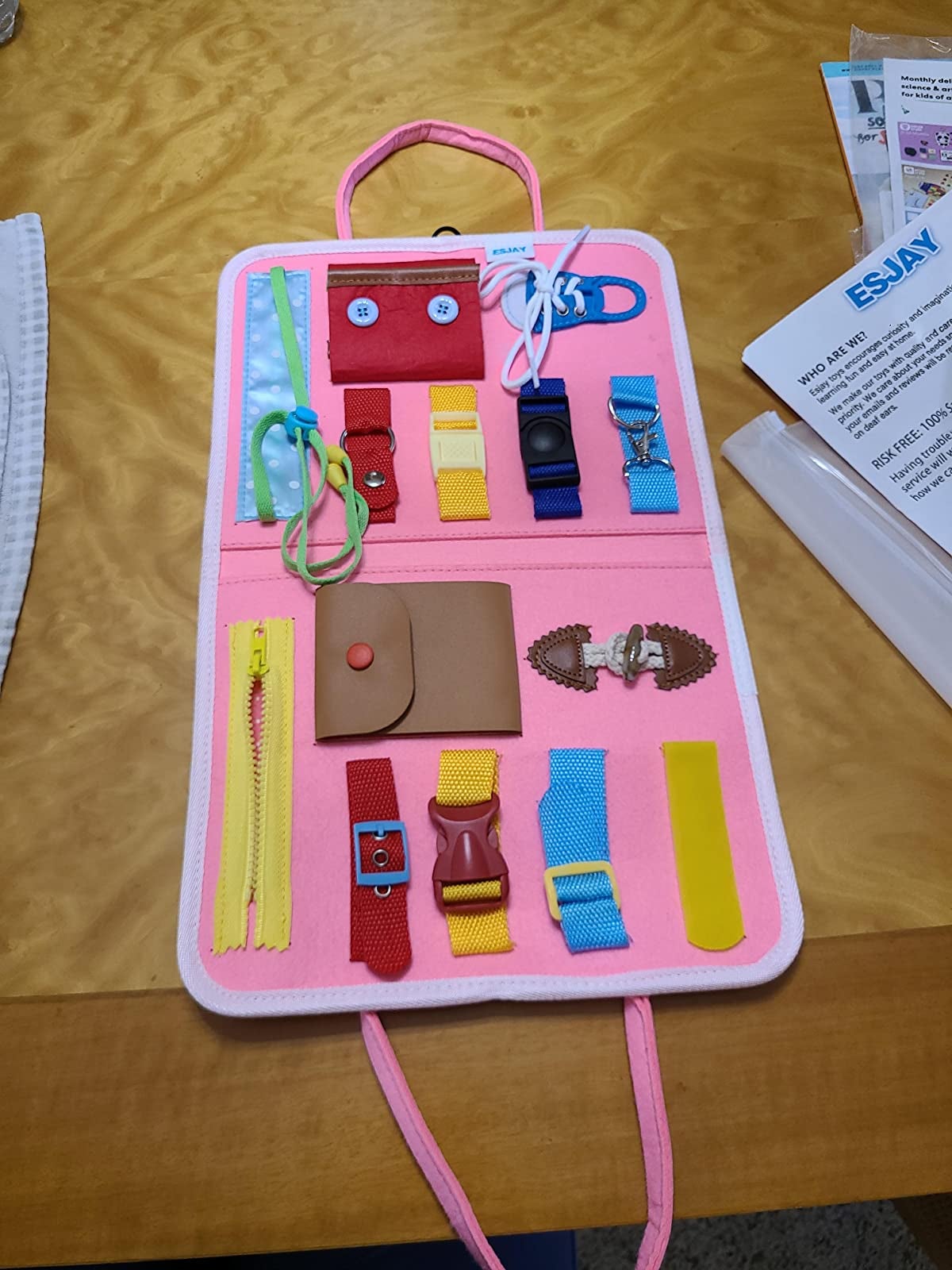 An activity board with zippers, buckles, and snap enclosures