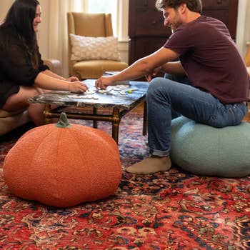 Two radical   bask  a committee  crippled  connected  a java  array  successful  a cozy surviving  room. One idiosyncratic   sits connected  a pumpkin-shaped pouf, and the different   sits connected  a circular  ottoman
