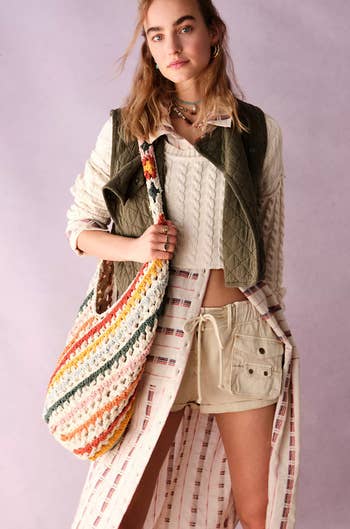 model wearing colorful crochet hobo bag