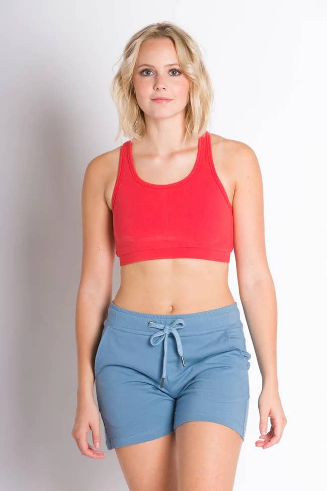model wearing the red sports bra with blue shorts