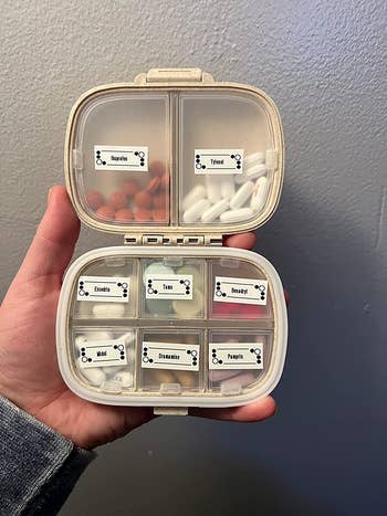 Lifestyle Reviewer retaining their tablet organizer stuffed with pills and with the compartments labeled 