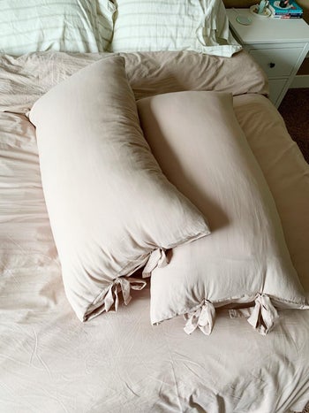 Two long rectangular pillows in tan pillowcases