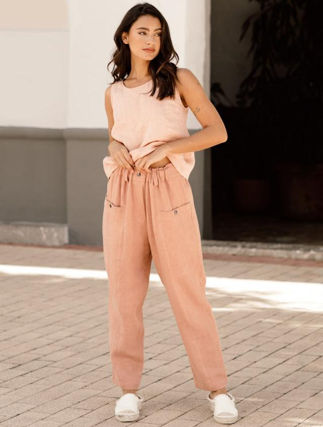 model wearing the coral pants with a peach tank and white shoes